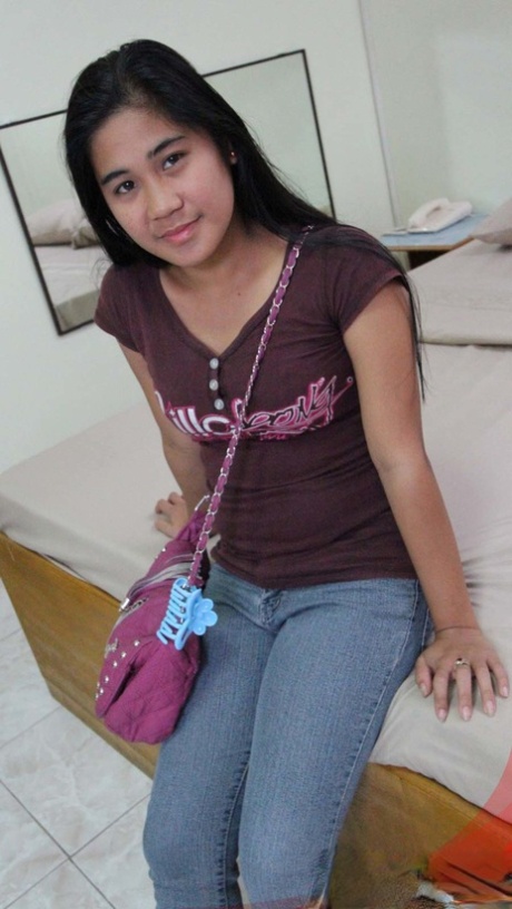 All clothes on: Filipina amateur Maya kneels down after taking off her clothing and then steps to bed.