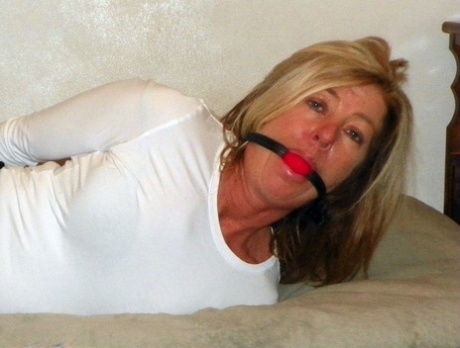 A black miniskirt bed, the naked blonde MILF is held over and ball gagged.