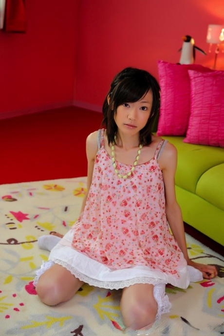 The image shows a petite Japanese girl with an attractive face wearing knee-length socks and non nude clothing.