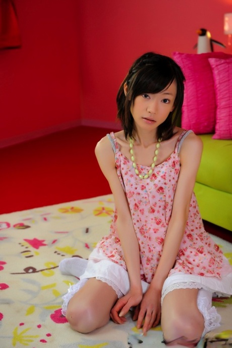 This is a small Japanese girl with a pretty face who is wearing knee socks but not nude.