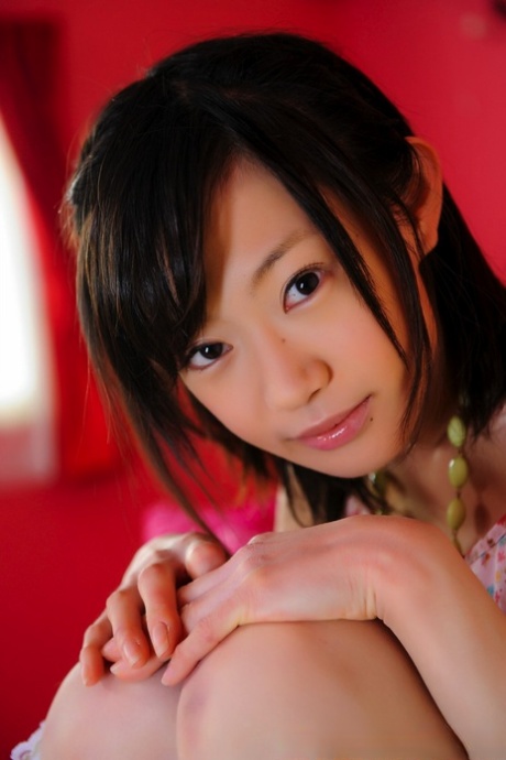 A petite Japanese female with a charming appearance poses without nude attire and wears knee-length socks.