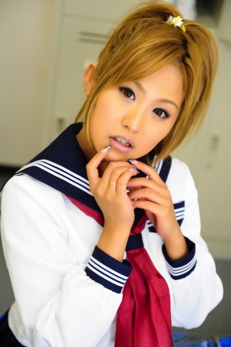 Cute little Japanese girl with a cute face poses for her lovely bench in the uniform.