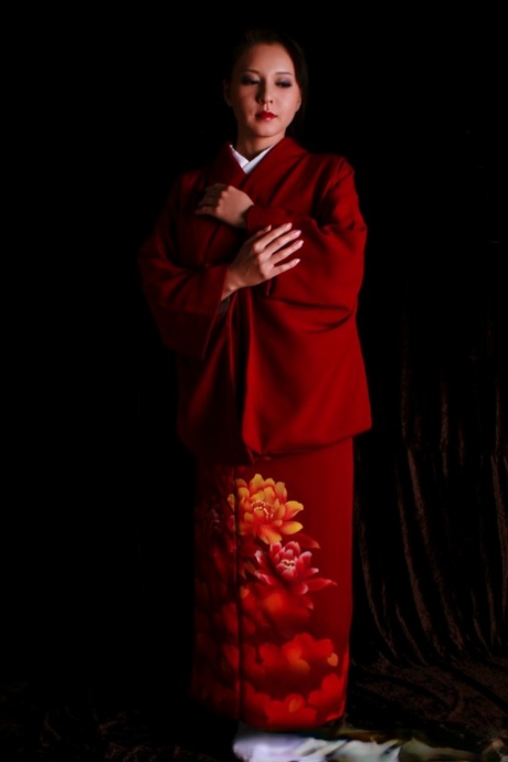 Traditional clothing of the Japanese woman with red lips and holding a knife.