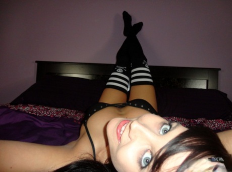 Dark haired teen Andi Land gets naked while wearing striped thigh highs