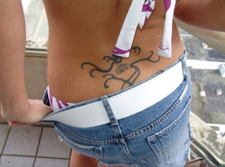 Teen amateur shows her tramp stamp in saggy bikini bottoms and red toenails