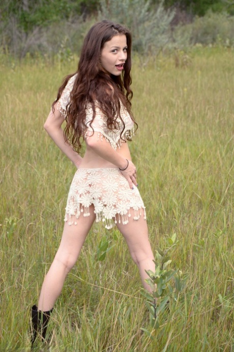 Long haired girl: Iva Nora, who is quite young at least, teases herself in a field.