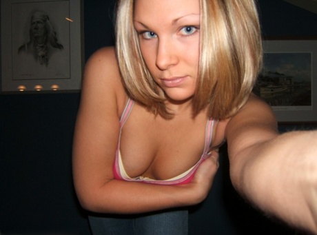 An amateur who is blonde curls her hair up during a tease solo shoot.