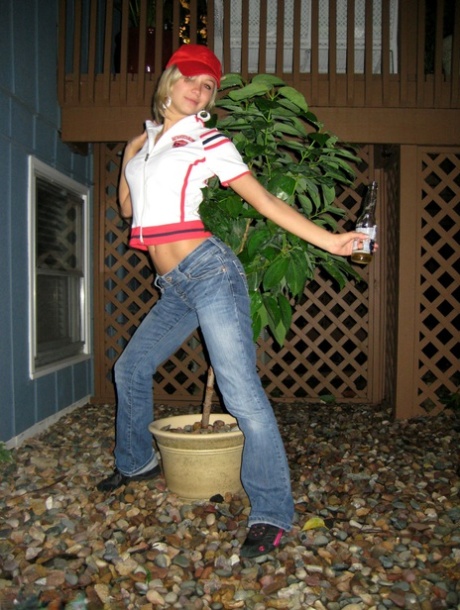 Kasia, a blonde amateur who is drinking at night, pees in the backyard while drinking.