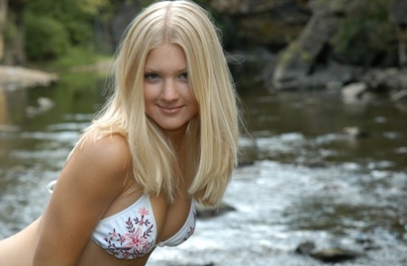 Young Blonde Girl Tiffany Models On Rocks In A River Wearing A String Bikini