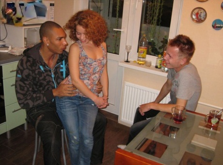 In front of her boyfriend, a young redhead engages in sexual activity with a black guy by sucking and choking him.