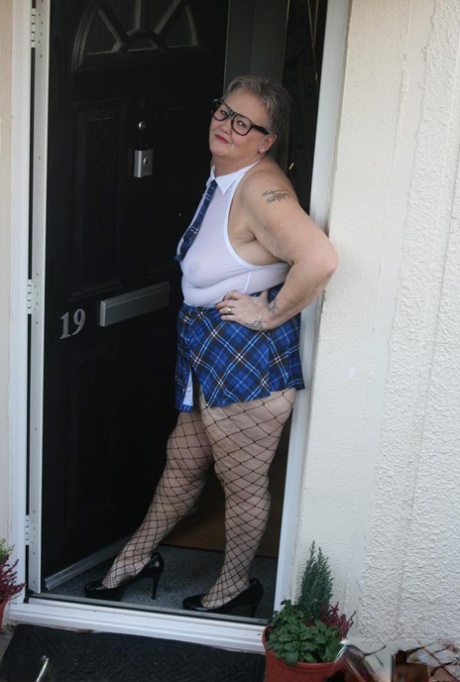 Valgasmic Exposed poses in sultry schoolgirl attire outside her home.