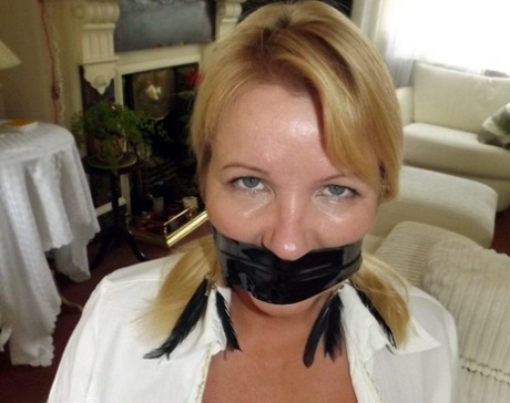 The tits of a blonde woman are tied up with rope and covered in duct tape to silence them.