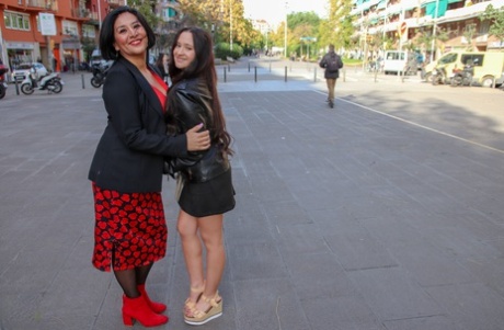 During lesbian sex, an older woman holds a young girl with a strapped cock in her genitals.