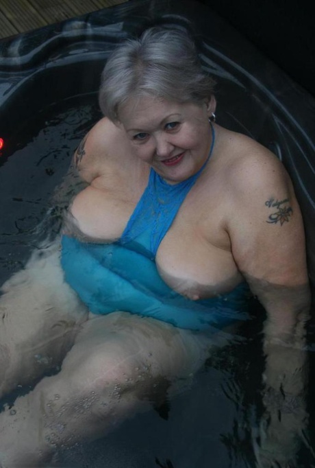 Chubby nan Valgasmic Exposed exhibits her tits and pussy in an outdoor hot tub.