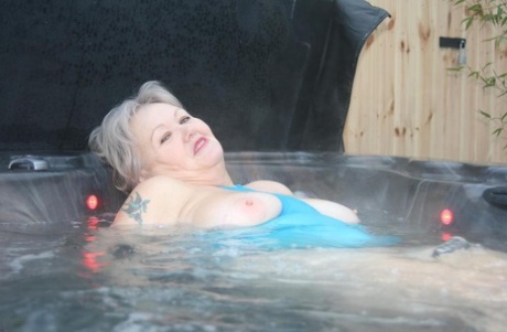 An outdoor hot tub is where Chubby nan Exposed exhibits her tits and pussy.