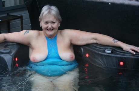 Chubby nan Exposed exhibits her vagina and pusses in an outdoor hot tub.