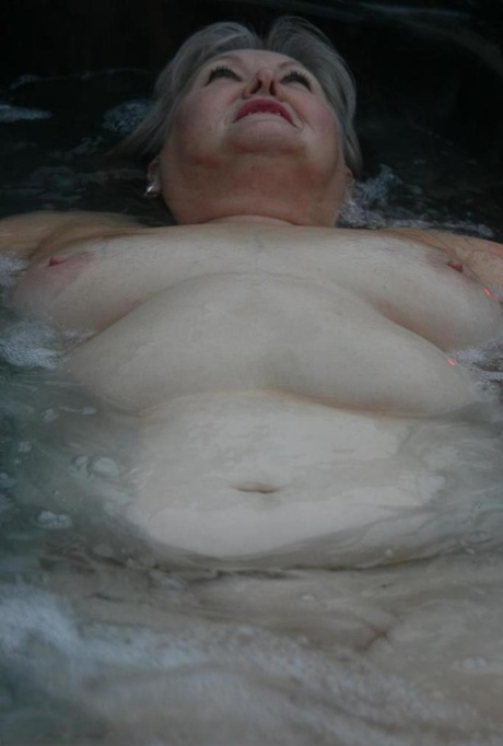 Fat oma transforms into nylons and heels after lounging in hot tub without clothes on.