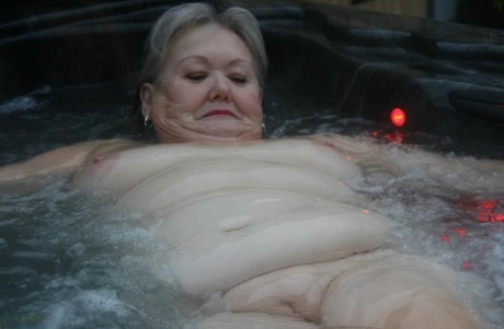 Fat oma switches from nude hot tub to nylons and heels.