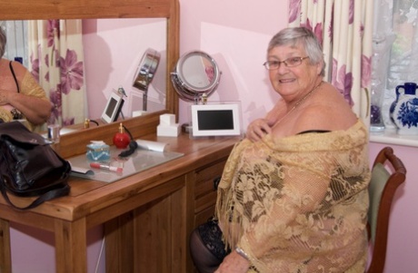 A senior citizen with short hair can perform her tits and pussy without any lingerie.