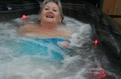 A female who is elderly experiences Valgasmic Exposed while hot tubing, playing with her breasts.