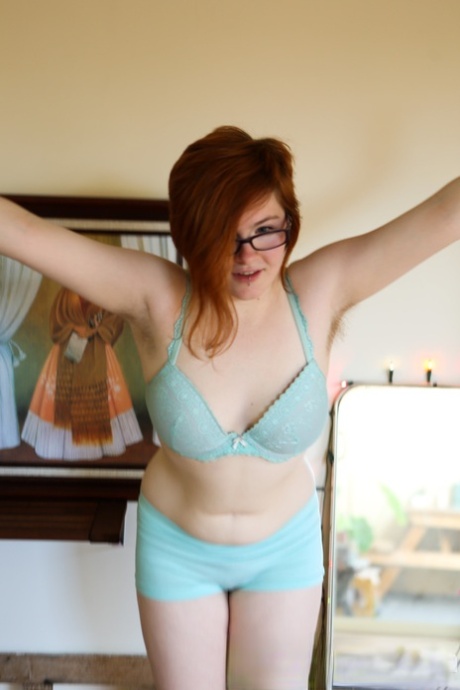 Panda, the chubby and unshaved redhead, poses with glasses on her face as a pale person.