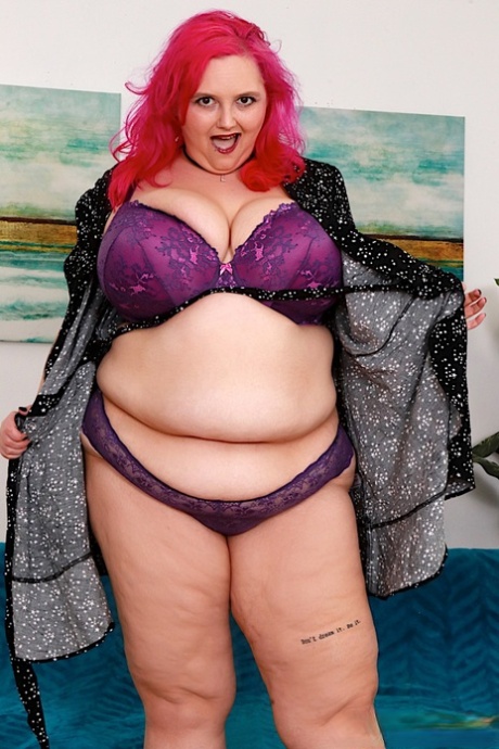 After undressing, the woman with pink hair on her right handpiece, SSBBW, uses her Sara Star finger to spread her legs.