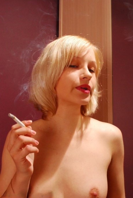 Blonde Teen Smokes While Undressing In A Bedroom Mirror
