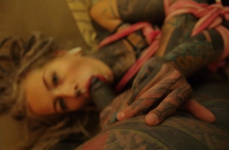 Heavily Tattooed Female Sucks A Black Cock And Masturbates While Tied Up