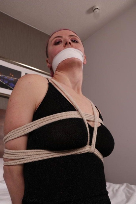 Fully clothed chick is tied up with ropes while silenced wit tape over mouth