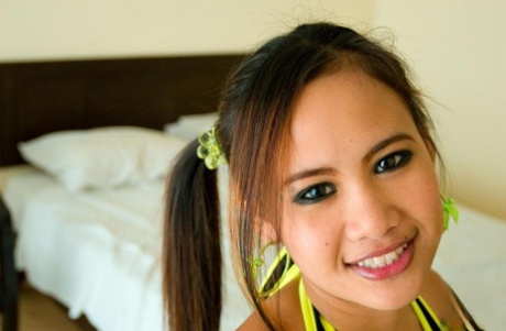 The adorable Asian girl named Beer is seen in pigtails, unclothed, and giving a blowjob.