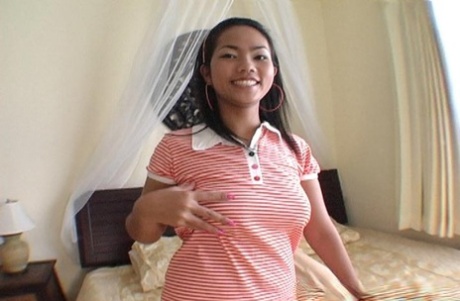 A beautiful Thai girl named Bim puts her nice tits on before having sexual intercourse on a bed.