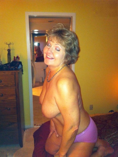 Busty Bliss, an older woman, displays her prominent breasts before POV sex is conducted.