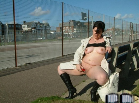 A public bench is used by a brunette fat girl to expose herself before she masturbates.