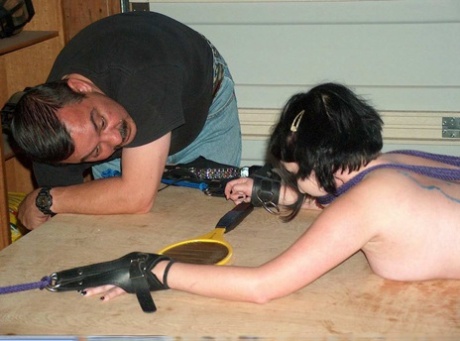 While in bondage, a girl with dark hair is subjected to hot wax that covers her posterior.