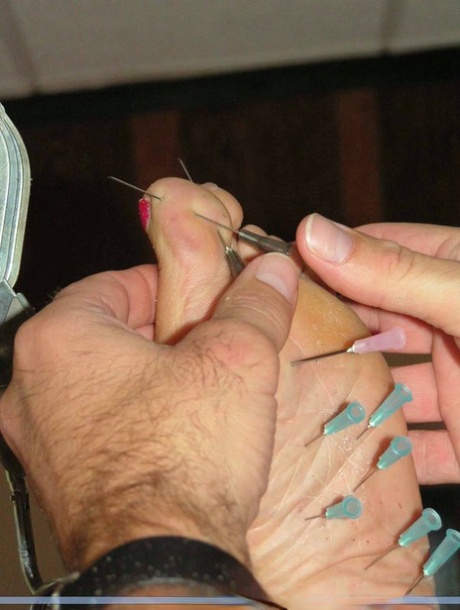 A female who is restrained has needles placed inside her feet without any attachment.