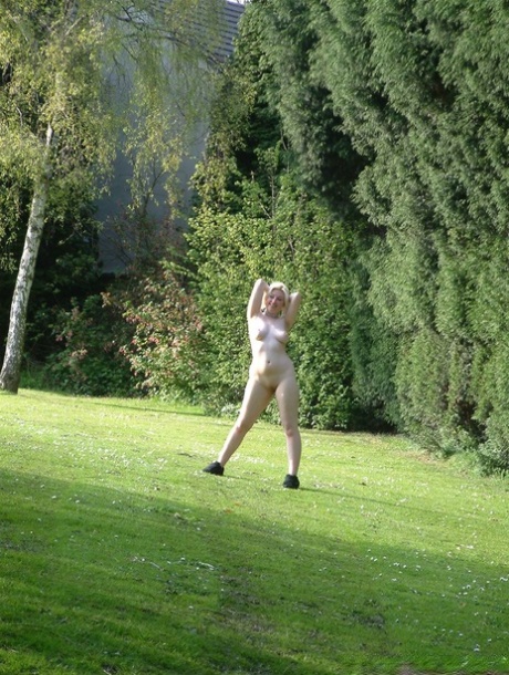 Yanus, with her crimson hair and blonde highlights, glides through a public field while wearing high-heeled sneakers.