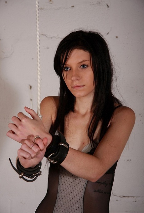 Dark haired chick is affixed with nipple clamps while restrained