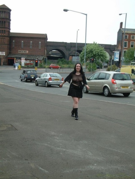 A pumper with dark hair can be seen wearing a transparent top while walking in public.