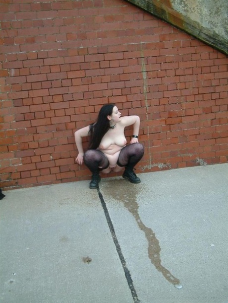 In the alley, a fat British slave releases urine from her nylons.