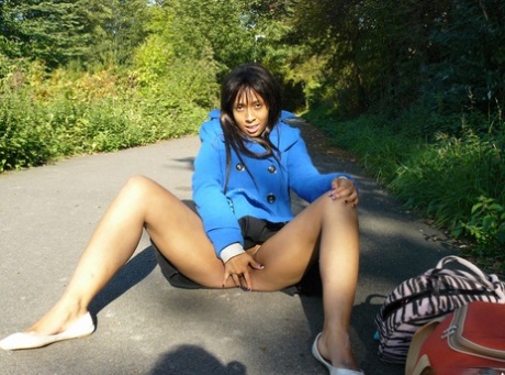 Ebony girl squirms in her vagina on the road as a jogger walks by.