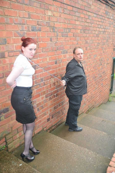 Redhead licks her Master's boots in the parking lot before crawling on all fours.