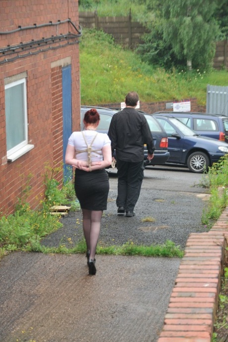 Prior to crawling on all fours, Redhead licks her Master's boots in the parking lot.