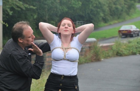 Prior to crawling on all fours, Redhead licks her Master's boots in the parking lot.