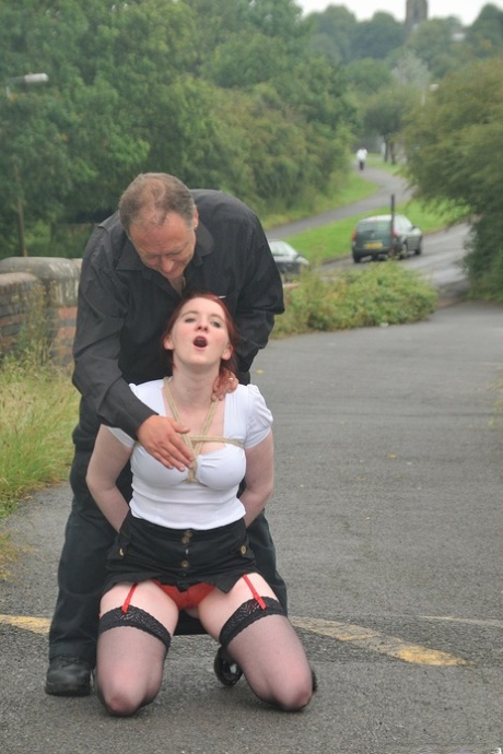 In the parking lot, Redhead licks her Master's boots and then crawls on all fours.