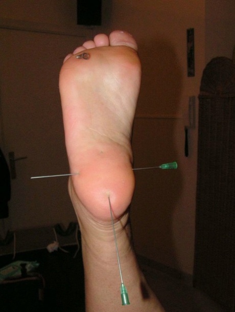 Needles are inserted into various body parts of the restrained white girl.