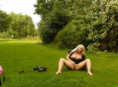 On a lawn, the curvy blonde masturbates before being accompanied by her lesbian partner.