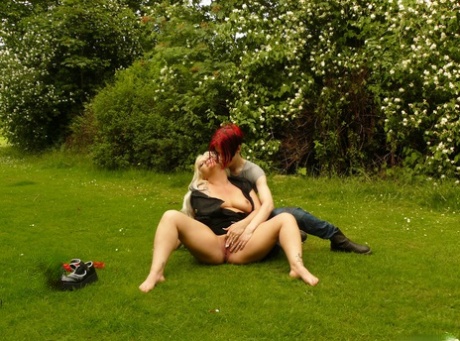 Her lesbian partner accompanies her masturbating on a lawn before she goes to join her.