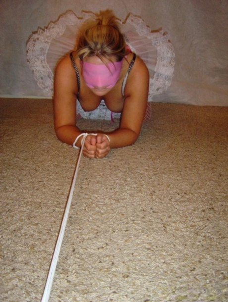 Blindfolded: Caucasian girl is seen tied up with rope and wearing a tutu, then heels.