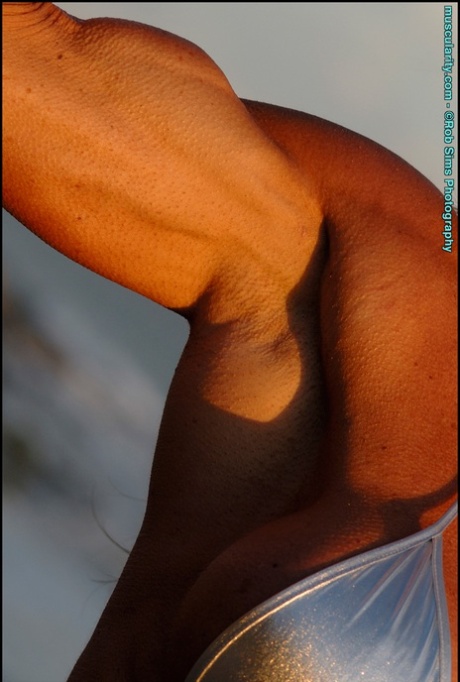 Bodybuilder Lynnie Brooks Poses On A Sandy Beach While Wearing A Silver Bikini
