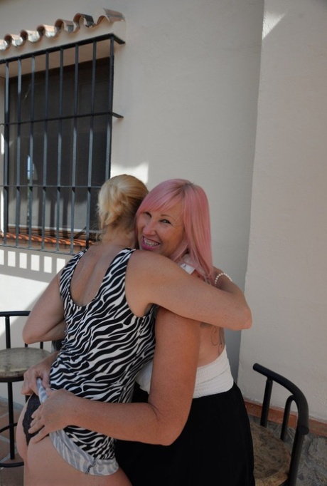 Melody, who is now a mature woman, and her lesbian lover enjoy wine while playing on the patio.